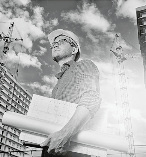 Construction professional holding building plans on site